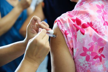 Aşı aşısı, doktor hasta koluna aşı enjekte ediyor.