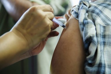 Aşı aşısı, doktor hasta koluna aşı enjekte ediyor.