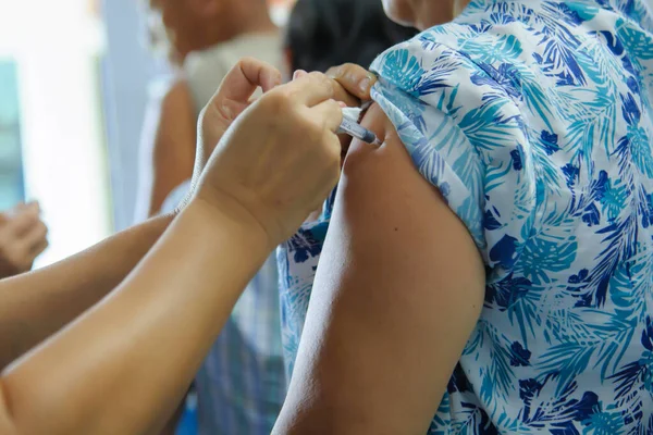 Aşı aşısı, doktor hasta koluna aşı enjekte ediyor.