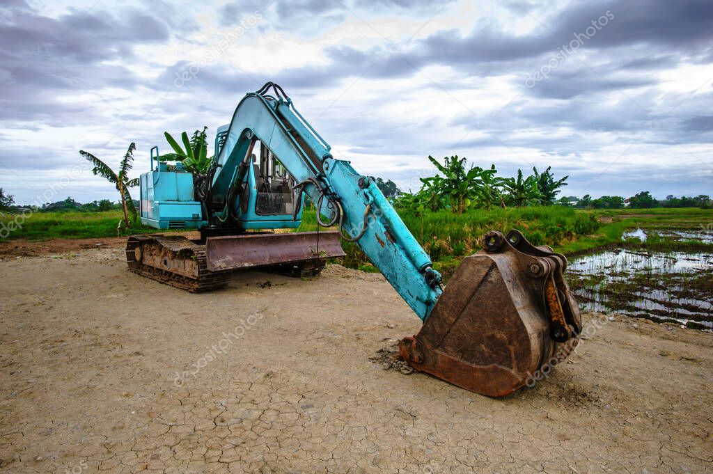 heavy excavator with shovel standing on hill