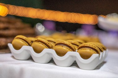 Kahverengi badem kurabiyeleri beyaz tepside yığılmış.