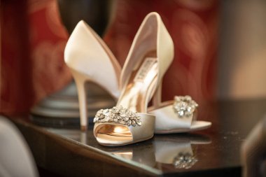Gelin stiletto beyaz ayakkabılar, önünde ve yanında mücevherler var.