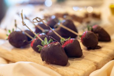 Tahta oyma tahtasında çikolata kaplı çilek.