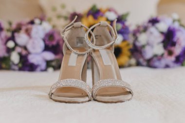 Sarı ayçiçeğinin önünde beyaz mücevherli ayakkabılar 