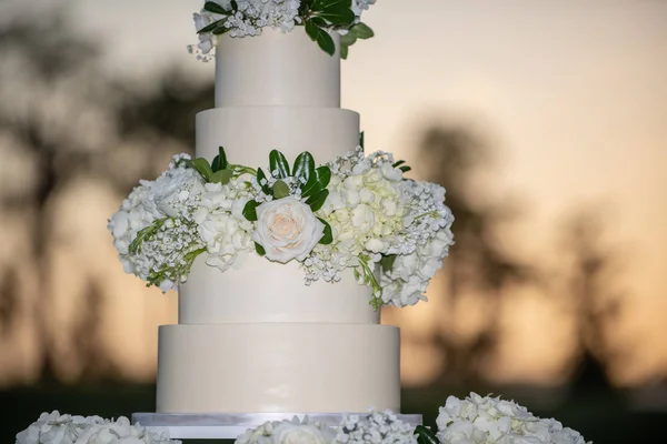 Tarta de boda blanca de cinco niveles con rosas blancas al aire libre puesta de sol —  Fotos de Stock