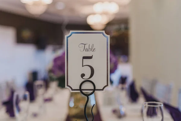 Wedding Receptie tafel nummer vijf plaats kaart op paarse tafel instelling — Stockfoto