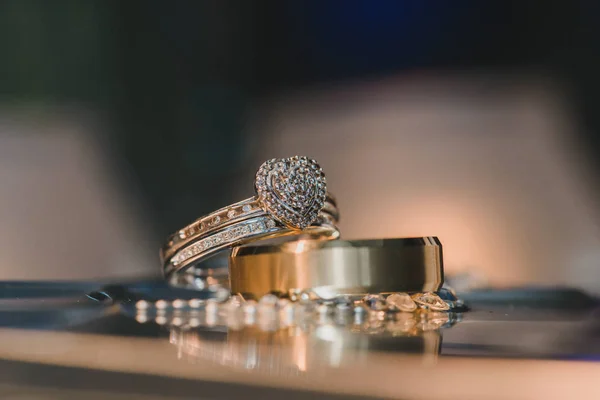 Bagues de mariage coeur d'or avec diamants sur table réfléchissante — Photo