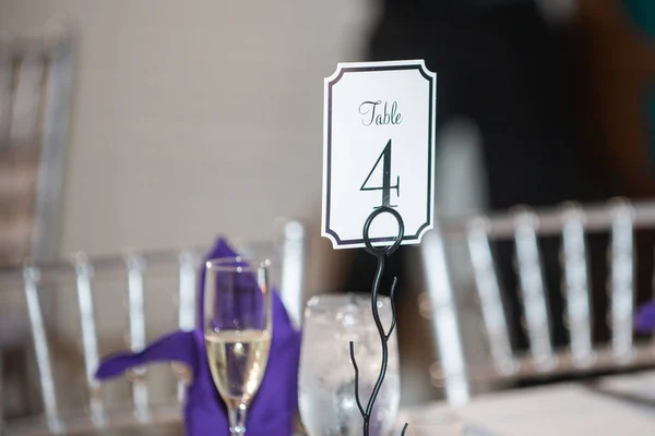 Wedding Receptie tafel nummer vier plaats kaart op paarse tafel instelling — Stockfoto