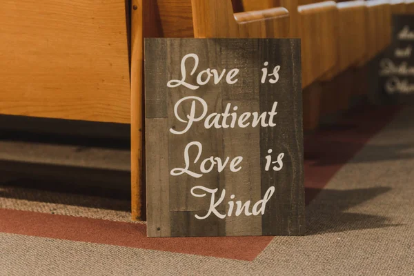 love is patient, love is kind inspirational wood sign in wedding