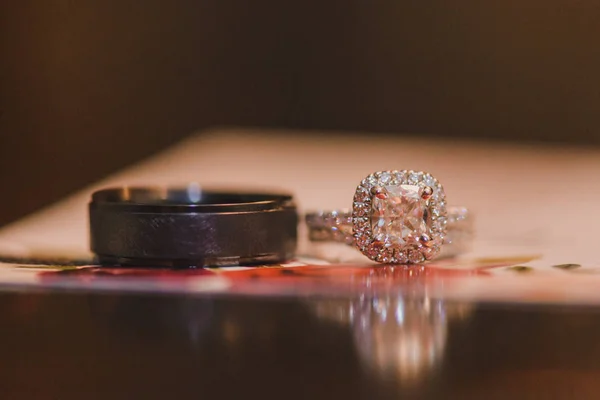 Anéis de casamento prata e preto com diamantes em surf reflexivo — Fotografia de Stock