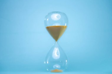 Kum saatiyle zamanı belli bir mesafeden kumla söylüyor. Şeffaf kum saati.