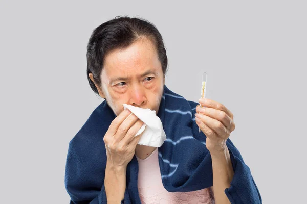 old asian woman feel sore throat have fever and sick