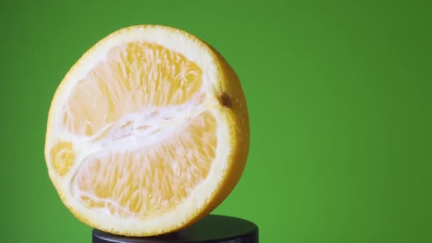 Girando laranja em um fundo verde — Vídeo de Stock