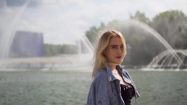 Beautiful Caucasian Blonde Girl Smiling Riverside Fountain Sunny Day — Stockvideo
