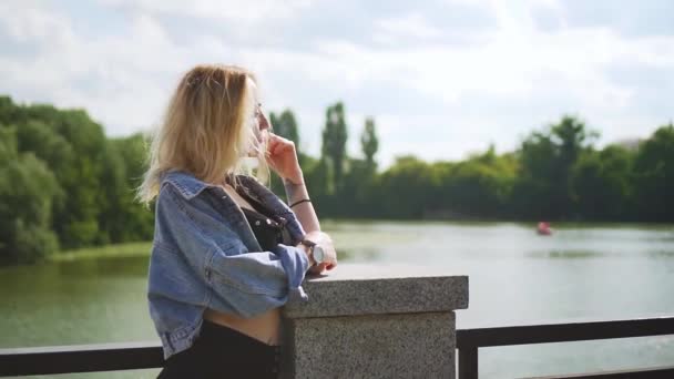 Piękna Biała Blondynka Dziewczyna Pobliżu Fontanny Nad Rzeką Słoneczny Dzień — Wideo stockowe