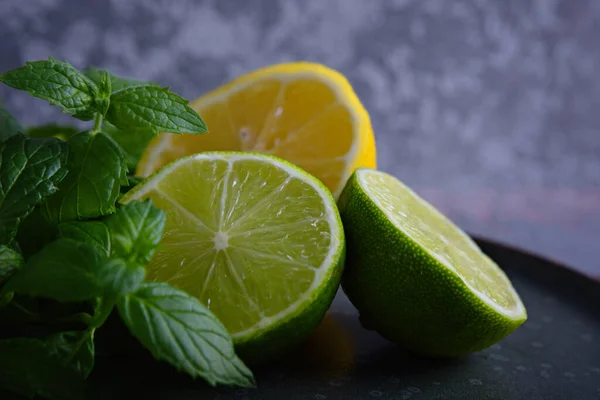 Lime, citron och mynta ligger på en tallrik. — Stockfoto