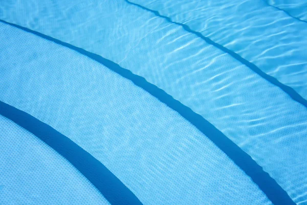 Het wateroppervlak in het blauwe zwembad. — Stockfoto