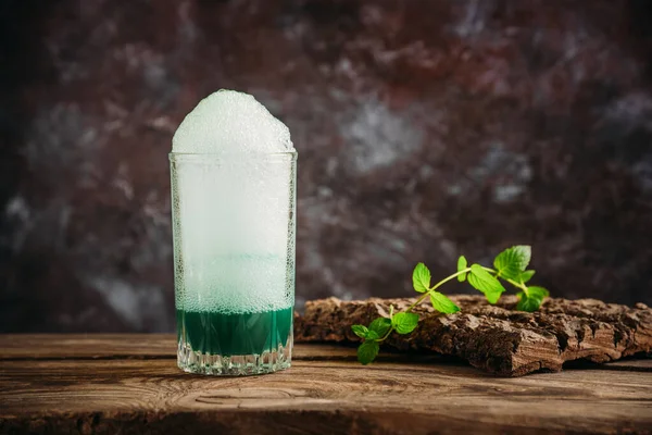 Zuurstofcocktail in een glas op een houten tafel. — Stockfoto