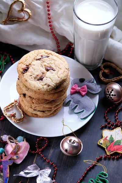 美国巧克力饼干 一杯牛奶和圣诞装饰品 深色木桌和粉红色背景 新年饼干 — 图库照片