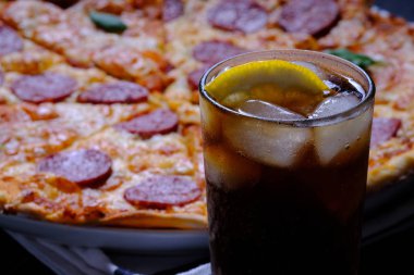 Pepperoni ve Margarita. Birlikte iki pizza ve ahşap masada bir kola
