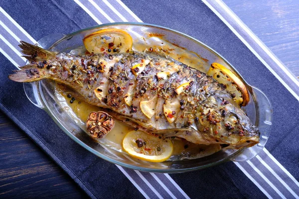 Limon, sarımsak, baharat ve otlar ile fırında pişmiş balık. Carp limon ile pişirme için bir çanak servis