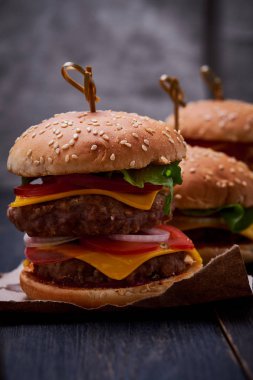 Üç farklı cheeseburger. İki pirzola ile çizburger, yumurta ve klasik çizburger ile çizburger. Peynirli Hamburgerler.