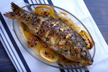 Limon, sarımsak, baharat ve otlar ile fırında pişmiş balık. Carp limon ile pişirme için bir çanak servis