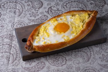 Bir ahşap tahta üzerinde adjar Khachapuri.