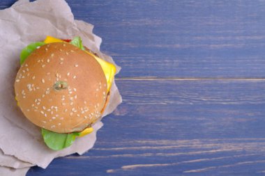 Klasik Amerikan cheeseburger. Ahşap arka planda cheeseburger.