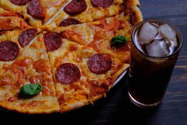 Pepperoni ve Margarita. Birlikte iki pizza ve ahşap masada bir kola