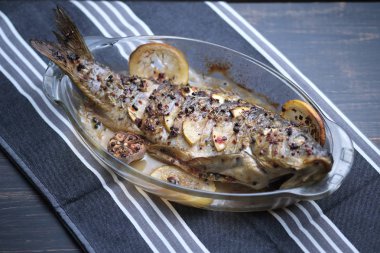 Limon, sarımsak, baharat ve otlar ile fırında pişmiş balık. Carp limon ile pişirme için bir çanak servis