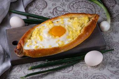 Ahşap bir tahta üzerinde adjar Khachapuri. Yemek için fırında kek servis edilir. Gürcü mutfağı.