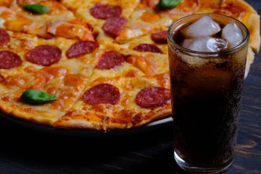 Pepperoni ve Margarita. Birlikte iki pizza ve ahşap masada bir kola