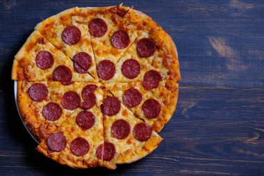 Pepperoni pizzası. Domates sosu, peynir ve baharatlı sosis ile klasik pizza. Ev yapımı pizza