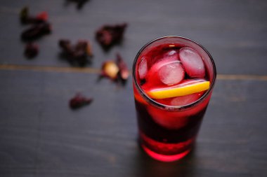Limon, bal ve buz ile Hibiscus çayı. Koyu ahşap arka planda çay
