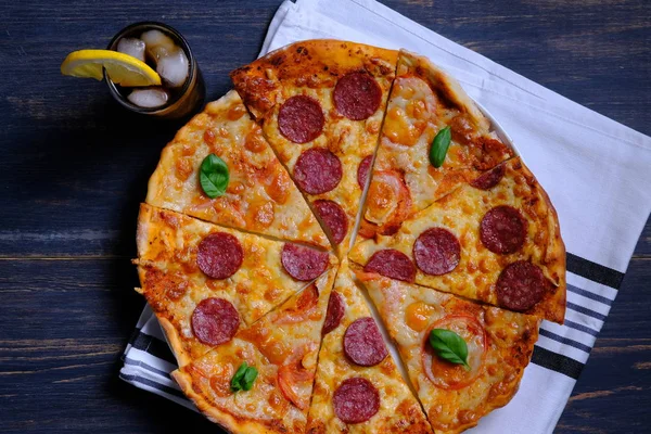 Pepperoni and Margarita. Two pizzas together and a cola on a wooden table