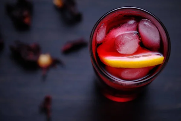 Limon, bal ve buz ile Hibiscus çayı. Koyu ahşap arka planda çay