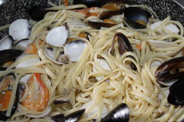 bir tabak makarna ve deniz ürünleri istiridye, karides, karides, midye ile