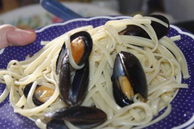 bir tabak makarna ve deniz ürünleri istiridye, karides, karides, midye ile