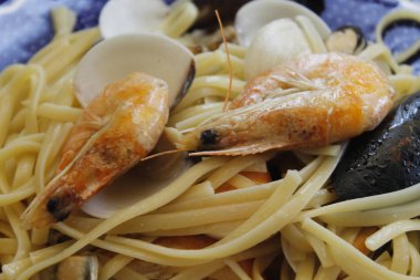 bir tabak makarna ve deniz ürünleri istiridye, karides, karides, midye ile