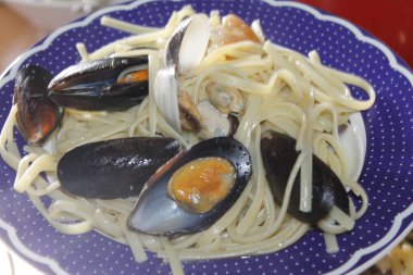 bir tabak makarna ve deniz ürünleri istiridye, karides, karides, midye ile