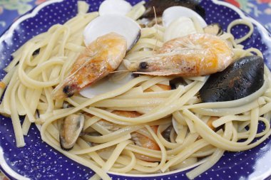 bir tabak makarna ve deniz ürünleri istiridye, karides, karides, midye ile