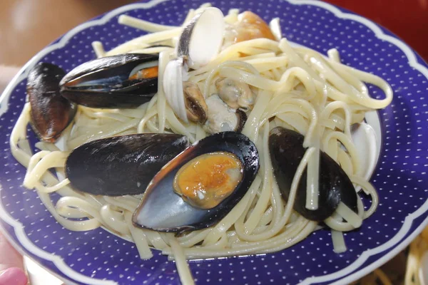 bir tabak makarna ve deniz ürünleri istiridye, karides, karides, midye ile