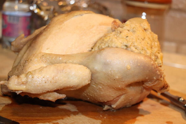 Сырая фаршированная курица на доске для резки дерева
