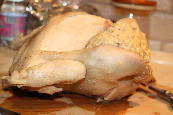 Сырая фаршированная курица на доске для резки дерева
