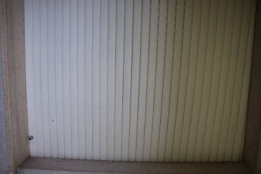 Dolu tarafından delinmiş beyaz koruyucu kepenkler.