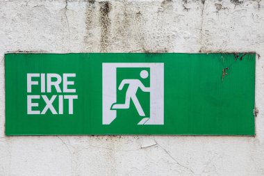 eski beyaz duvarda yangın çıkış işareti