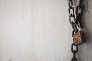 Zincir ve asma kilit duvarda paslanmış. 