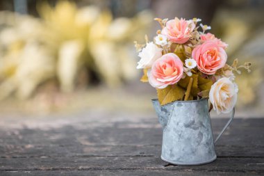 Tahta masadaki sürahide güller 