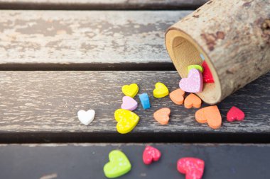 Tahta bir fincanda bir çok küçük kalp rengarenk